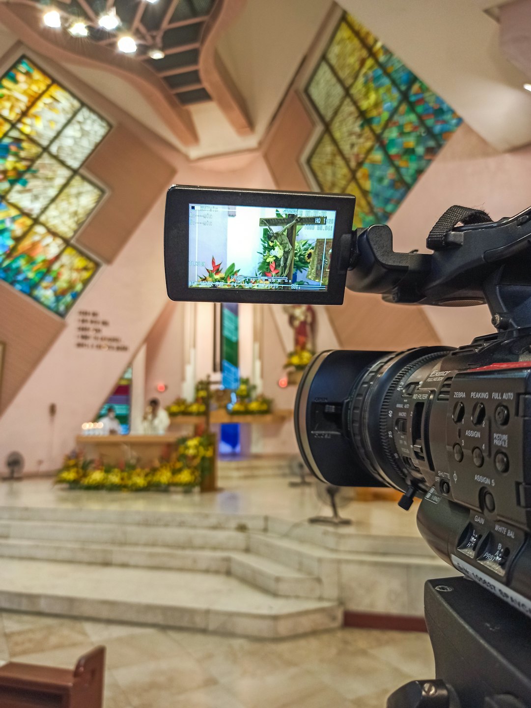 Professional video camera recording a church altar during an event.